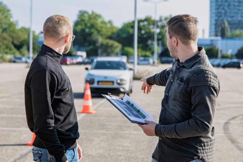 Potential driving instructors beside dual control car